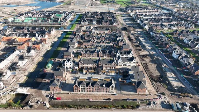 Building and construction of modern suburb housing. Scaffolding residential properties exterior urban development project. Houses in the Netherlands. Aerial drone view.