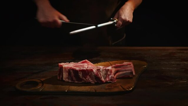 Chef sharpening knife in front of cutting table.