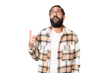 Young man with beard over isolated chroma key background pointing up and surprised