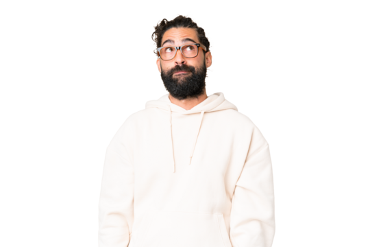 Young man with beard over isolated chroma key background having doubts while looking up
