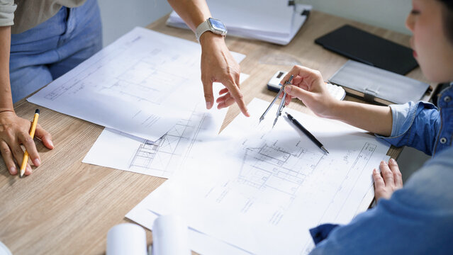 Engineering construction concept, Female engineer use geometry compass drawing circle in blueprint