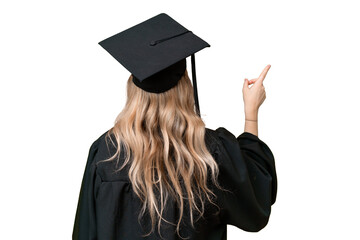 Young university English graduate woman over isolated background pointing back with the index finger