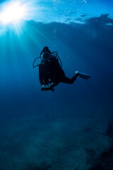 scuba diver at safety stop under the sun