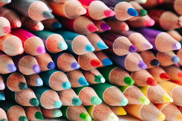 Tightly packed crayons in a stack. Colored tips close up.