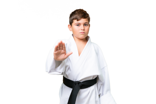 Little caucasian kid doing karate over isolated chroma key background making stop gesture
