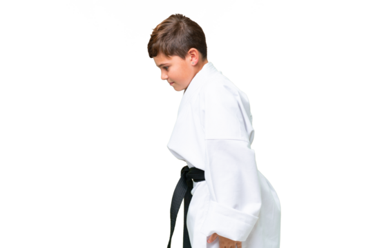 Little caucasian kid over isolated chroma key background doing karate and saluting