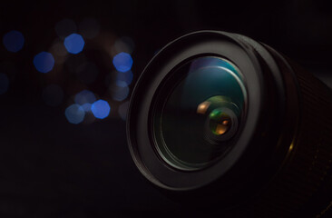 Camera lens close-up, lights out of focus on the background