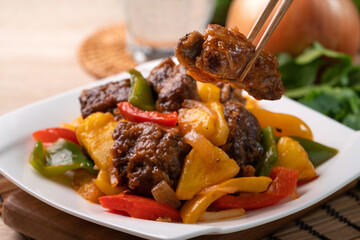 Sweet and sour sauced deep fried pork ribs with chopped pepper and pineapple.