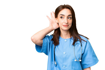 Young nurse woman over isolated chroma key background listening to something by putting hand on the ear