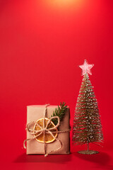 christmas gifts near small christmas tree on red background. Greeting card