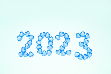 Fototapeta na wymiar New Year 2023 inscription from glass hearts on a blue background. Pantone color 2023. Idea and creativity. Valentine's Day. Christmas with loved ones. Horizontally, banner. High quality photo