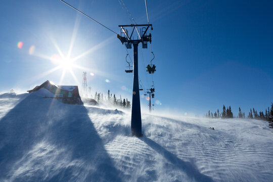 View from mount peak on Sheregesh ski resort and Altai mountains or Gornaya Shoria. Active winter rest, skiers and snowboarders on ski slope and Ski lift, beautiful nature and sport leisure.