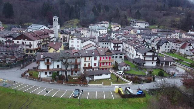 Aerial drone view of the city of Barcis, mountains with snow and fog, emerald lake and autumn trees