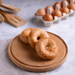 Bagels on a round wooden board, on a gray background. Place for text