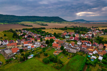 Fototapeta premium Aer ial view of a German village surrounded by meadows, farmland and forest in Germany.