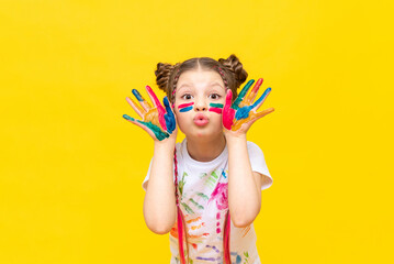 A little girl stained in multicolored paints is fooling around.  Children's creativity, drawing. Draw with your hands. The art of creating paintings for schoolchildren. - obrazy, fototapety, plakaty