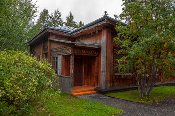 Reiny clouds in the cold autumn sky over  village with small wood log local houses and low fences in the park. Travelling on the suburb roads. People living