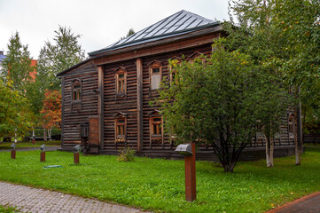 Reiny clouds in the cold autumn sky over  village with small wood log local houses and low fences in the park. Travelling on the suburb roads. People living