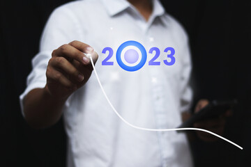 Finger pressing blue start 2023 button on virtual interface  with copy space for text. Concept of new year. Businessman pressing 2023 start up business. Beginning of New Year 2023