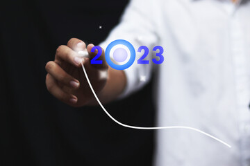 Finger pressing blue start 2023 button on virtual interface  with copy space for text. Concept of new year. Businessman pressing 2023 start up business. Beginning of New Year 2023