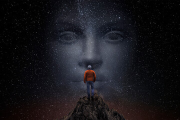Man on top of a mountain observes the universe with a woman's face