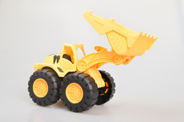 Construction plastic backhoe tractor toy isolated on a white background