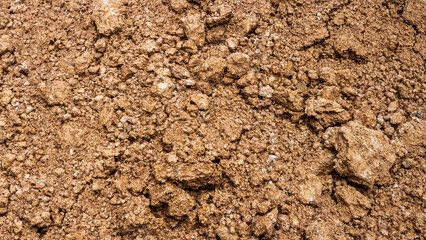 Close-up view of the wet brown sandy gravel surface after a torrential downpour.