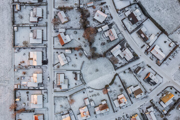 Aerial view on little European village in Sweden in winter, many private houses. Snowy weather, sunset. Warm sunlight. 