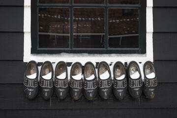 Black clogs against the background of a wooden wall. - 554673376