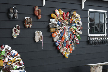 Colorful clogs against the background of a wooden wall. - 554673393