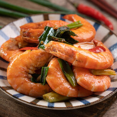 Delicious pan-fried shrimp on dark wooden table background.