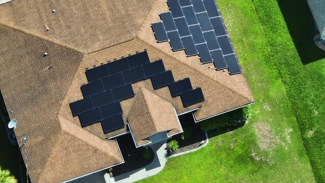 Aerial view of typical american building roof with rows of blue solar photovoltaic panels for producing clean ecological electric energy. Renewable electricity with zero emission concept
