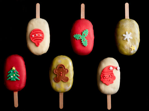 Colored popcycles on black background. Christmas sweets.