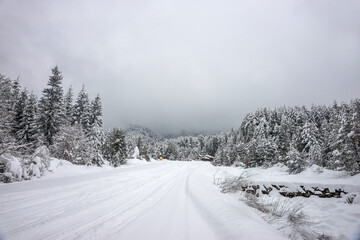 Ski road in Bansko ski resort after snowfall. Glazne river and Peshterite restaurant near ski slope in winter day.