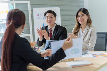 A group of young Asian businessmen Talking and planning work happily and have fun. at the company's office