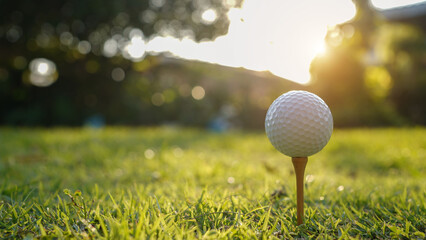 Golf ball on tee in a beautiful golf course with morning sunshine.