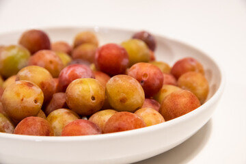 plate full of small raw plums