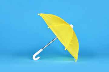 Yellow doll umbrella on blue background