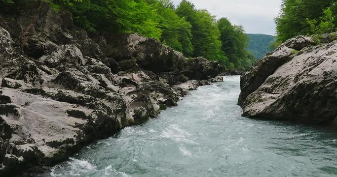 Aerial view of Mountain river and road. Flying over a mountain gorge. Slow motion 120 fps.