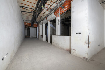Raw room with interlocking metal beams in a renovated building and corrugated plastic pipes for...