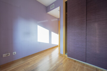 A built-in wardrobe with fuchsia sliding curtains as doors to match the paint on the walls of an...