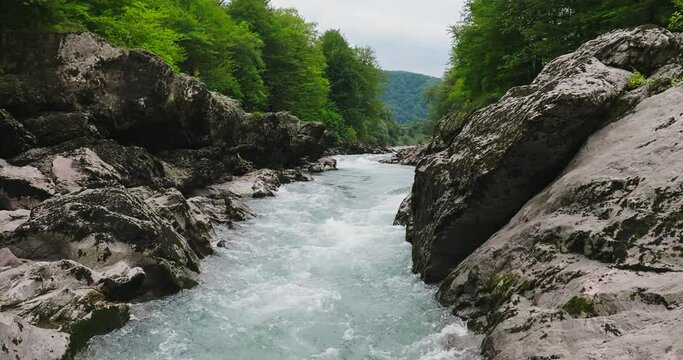 Aerial view of Mountain river and road. Flying over a mountain gorge. Slow motion 120 fps.