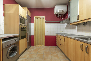 kitchen with wooden furniture, gray countertop, red walls and a hot water thermos on the ceiling