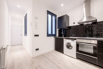 Newly installed kitchen with contemporary design with black wooden cabinets with matching...