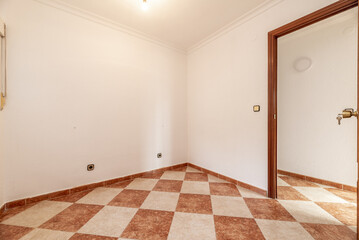 Empty room with two-color stoneware floor, skirting board of the same material and white walls