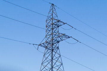 Mast of a high-voltage power line against the blue sky.