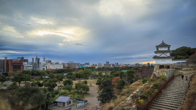 Sunset breaks through fast moving clouds over historic Japanese Castle