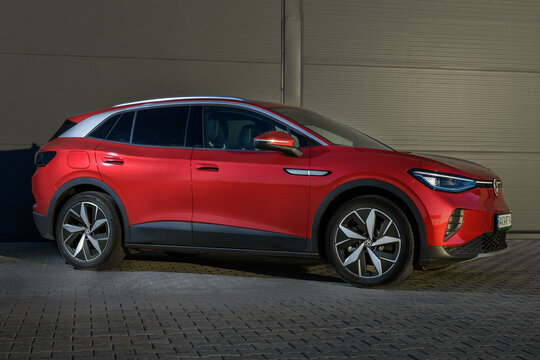 Kyiv, Ukraine - October 7, 2022: Red Volkswagen ID.4 in front of gray storehouse