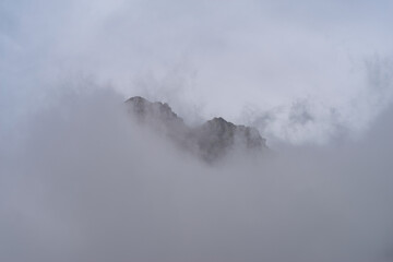 Rocky mountain peaks come out of the clouds, Maira Valley, Italian Cottian Alps