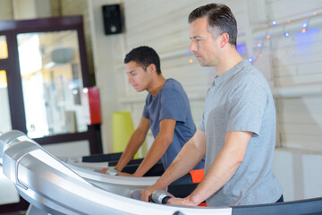 Two men on exercise machines